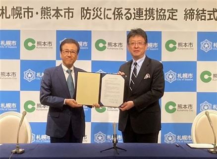 協定書を持つ札幌市秋元市長と大西市長（サイズ変更）