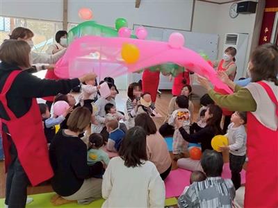 大きなシフォン布と風船で遊ぶこどもたちの様子