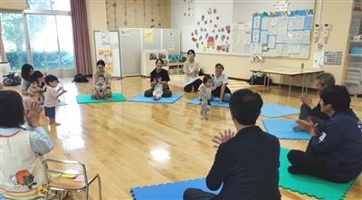 輪になり座って手をたたく写真