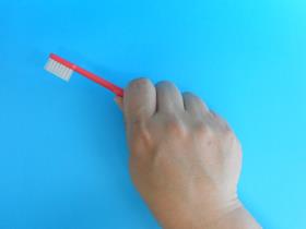 歯ブラシを手全体で握りしめたパームグリップの写真