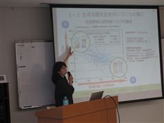 講師がスクリーンを指さしながら説明している様子 講師がスクリーンを指さしながら説明している様子